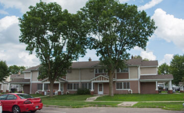 two large trees in front of multi family housing unit