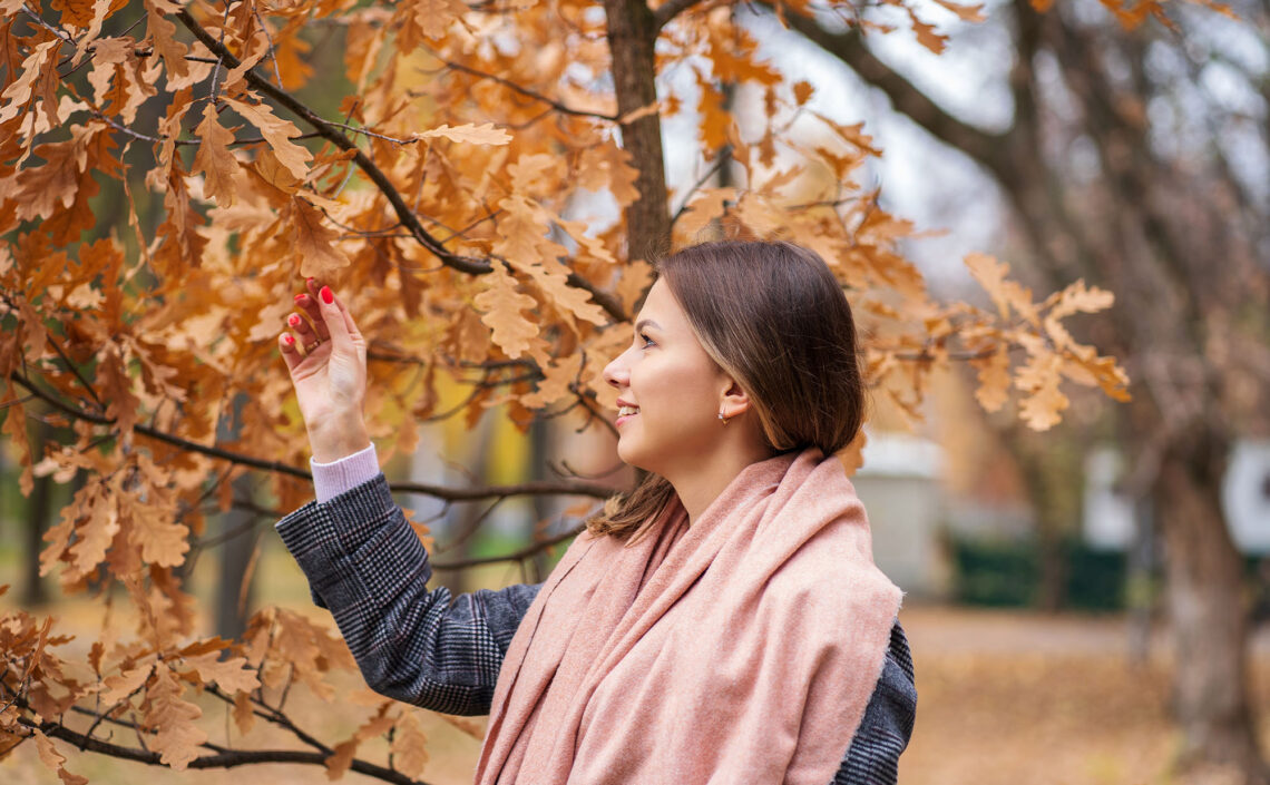 A woman touching fall oak leaves